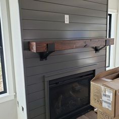 a room with a fire place and boxes on the floor