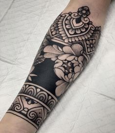 a black and white tattoo with flowers on the left arm, in an ornate style