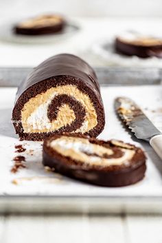 a chocolate roll is cut in half and ready to be eaten