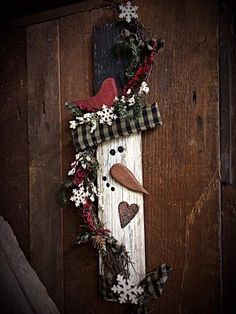 a snowman made out of wood is hanging on the wall with christmas decorations around it