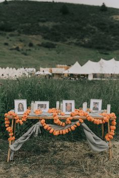 an orange flowered table is set up for a wedding reception with pictures on it