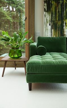 a living room filled with green furniture and plants