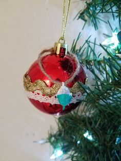 a red ornament hanging from a christmas tree