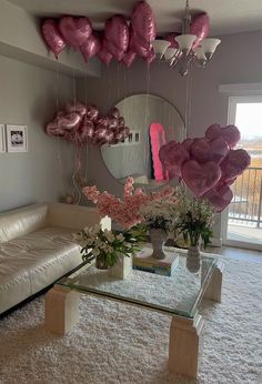 a living room filled with lots of balloons and flowers on the wall next to a couch