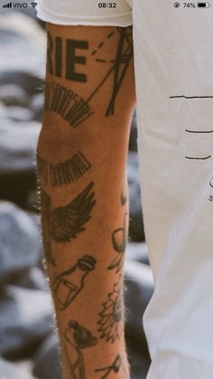 a man's arm with tattoos on it next to a white t - shirt