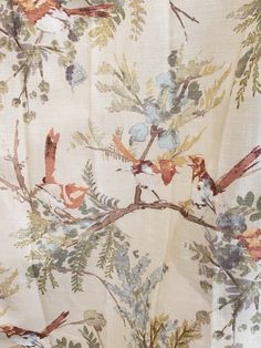 the fabric has birds on it and is white with green, blue and red flowers