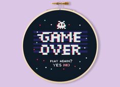 a cross stitch pattern with the words game over written in white and black letters, on a purple background