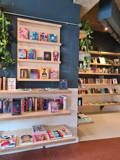 the bookshelves are filled with children's books and have plants growing on them