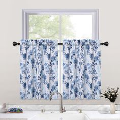 a kitchen window with blue and white curtains