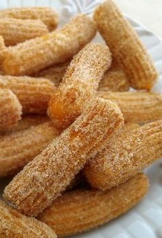 some sugar coated donuts on a white plate