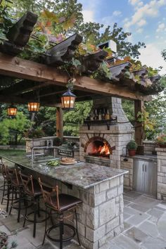 an outdoor kitchen with stone counter tops and grill