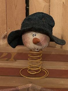 a snowman with a black hat on top of a wooden table