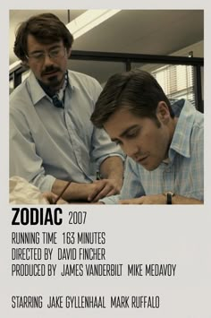 two men sitting at a table writing in front of a poster with the caption zodiac 2007 running time 138 minutes directed by david fincher produced by james vanderbit