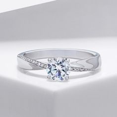 a diamond ring on a white surface with diamonds in the band and side stones around it