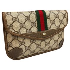 This vintage GUCCI pouch bag is crafted of GG monogram canvas in brown trimmed with brown pigskin leather. Front snap closure opens to an un-lined interior. This pouch has been altered by adding metal eyelets on the back to secure a chain. Made in Italy. Measures approximately 7.5 x 5 x 0.5 inches. comes with non-Gucci chain) Condition - Very good vintage condition with minor scuffs and marks on leather trimmings Gucci Pouch Bag, Gucci Pouch, Web Detail, Red Web, Vintage Fendi, Line Line, Gucci Outfits, Gucci Vintage, Gucci Tote