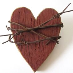 a wooden heart with barbed wire in the shape of a heart on a white background