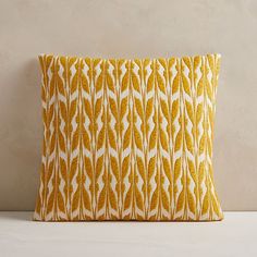 a yellow and white decorative pillow sitting on top of a table