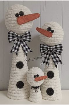 three snowmen made out of yarn with black and white bows