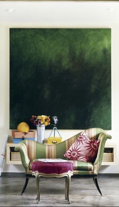 a living room filled with furniture and a painting on the wall