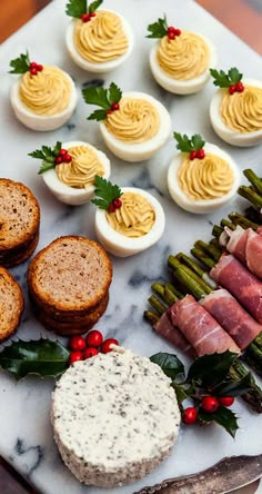 an assortment of appetizers are arranged on a marble platter with asparagus and deviled eggs