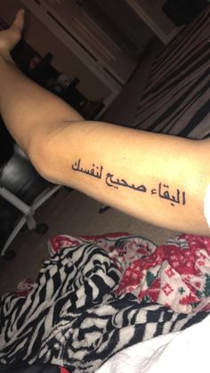 a person with a tattoo on their arm that says, i love you in arabic