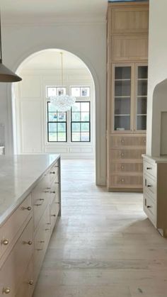 a large kitchen with an archway leading to the dining room