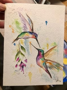 a painting of two hummingbirds flying next to each other with watercolors on paper