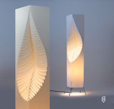 two tall white lamps sitting next to each other