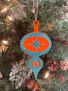 an orange ornament hanging from a christmas tree