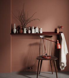 a wooden chair sitting in front of a shelf filled with vases and other items