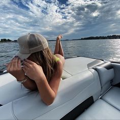 a woman sitting on top of a boat in the water