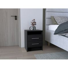 a black night stand next to a bed