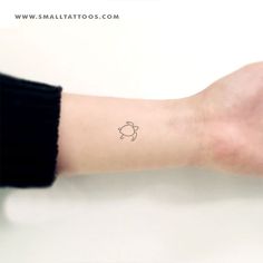 a person's arm with a small turtle tattoo on the left side of their arm