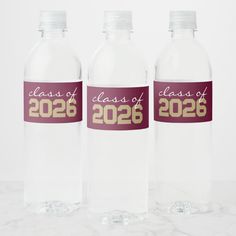 three clear water bottles with class of 205 printed on them