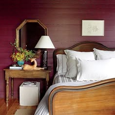 a bedroom with purple walls and white bedding