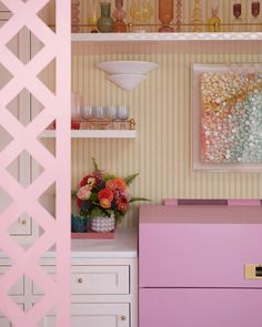 a pink chest sitting next to a white dresser