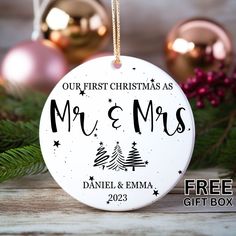 a personalized christmas ornament hanging from a tree with ornaments in the background