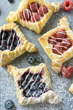 several pastries with berries and blueberries on a table