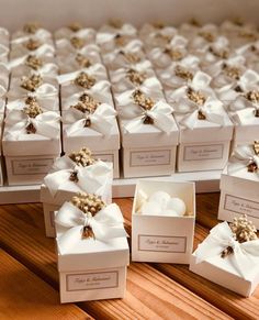 many boxes with white bows are sitting on the table