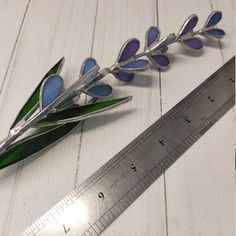 a pair of scissors sitting on top of a wooden table next to a flower shaped object