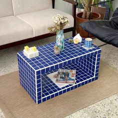 a blue and white coffee table sitting on top of a rug next to a couch