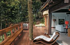 a wooden deck with chaise lounge chairs and trees in the backgrounge