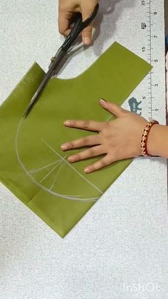 a person cutting out a piece of paper with scissors