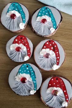 four decorated cookies sitting on top of a wooden table