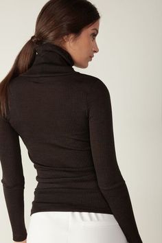 Long-sleeve high-neck tubular top made from a wool-silk blend. Stretch Merino Wool Tops In Solid Colors, Fitted Merino Wool Tops For Layering, Stretch Merino Wool Solid Top, Stretch Merino Wool Solid Color Tops, Stretch Merino Wool Turtleneck Top, Fitted Fine Knit Merino Wool Tops, Fitted Merino Wool Fine Knit Tops, Merino Wool Turtleneck Top, High Neck Merino Wool Tops For Fall