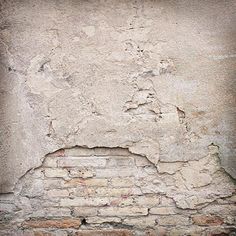 a fire hydrant sitting on the side of a building next to a brick wall