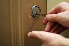 a person is opening a door with a key in their left hand and another hand holding the handle