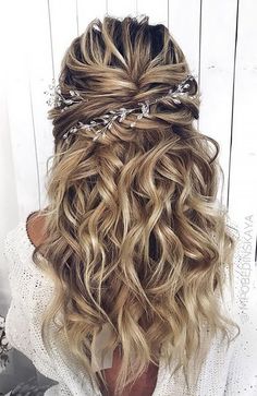 the back of a woman's head with wavy hair and braids in it