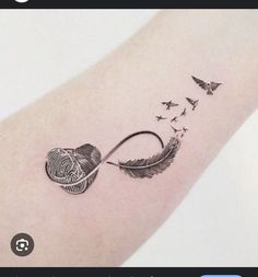 a tattoo on the arm of a woman with an arrow and birds flying around it