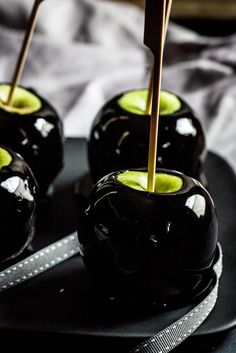 several black apples with green and white toppings on a plate, ready to be eaten